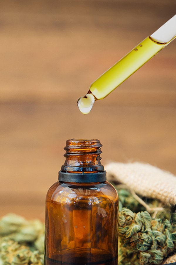 a bottle of marijuana oil being filled with a dropper.